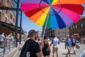 Man holding rainbow umbrella