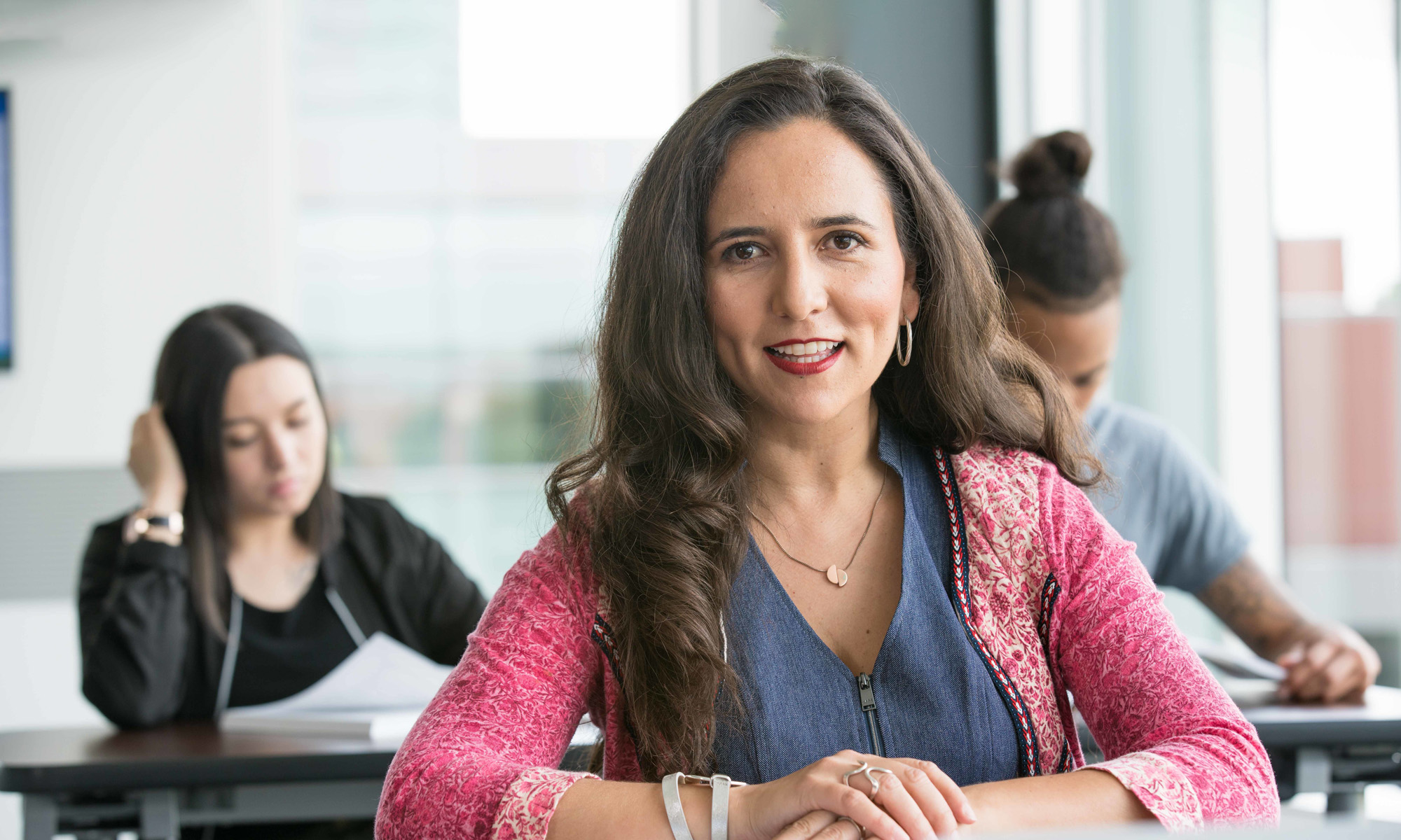 Excited female student in classroom with other students